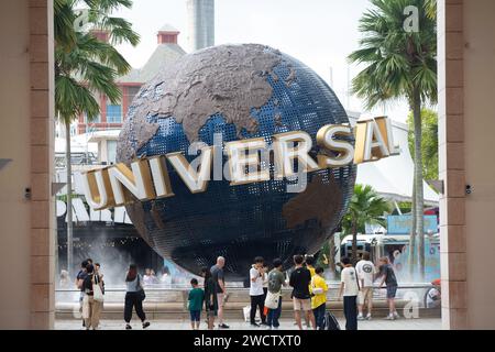 Touristen, die hauptsächlich asiatischer Ethik sind, sprechen Bilder auf der berühmten Weltkugel mit den Worten Universal in den Universal Studios Singapore in Sentosa. Stockfoto