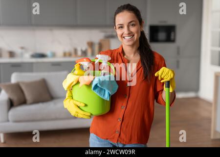 Freundliche Reinigung mit Eimer und Mopp bereit für die Hausarbeit Stockfoto