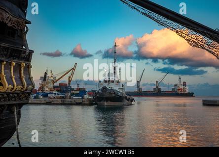 Ein Schlepper und Containerschiffe, die im Hafen von Sousse in Tunesien am Mittelmeer festgebunden sind. Stockfoto