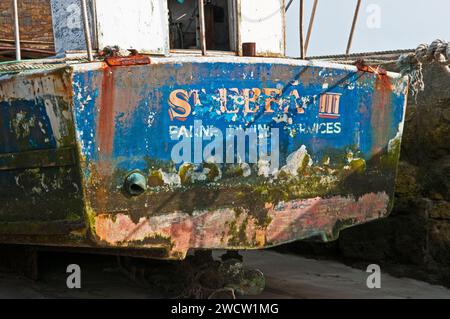 Verlassenes Fischerboot, das im März an der Hafenmauer von Beadnell an der Küste von Northumberland befestigt war. St Ebbs Third und Farne Boating Services Stockfoto