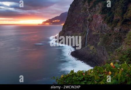 Madeira Island - dramatischer Sonnenaufgang über dem atlantischen Ozean mit Wasserfalllandschaft von Miradouro do VEU da Noiva Stockfoto