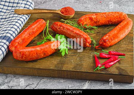 Die verschiedenen Hot Dogs, geschmückt mit aromatischen Kräutern und Paprika auf einem Holzbrett Stockfoto