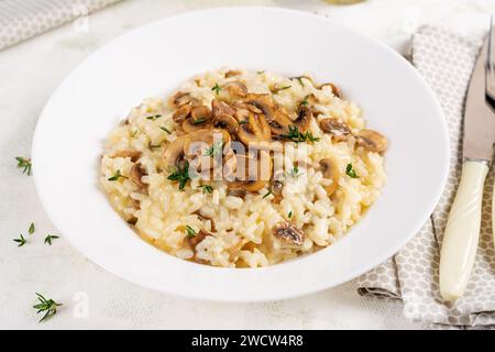 Gericht mit köstlichem Risotto mit Pilzen in Teller. Reisbrei mit Pilz und Tmyne. Warme Gerichte, italienische Küche. Stockfoto