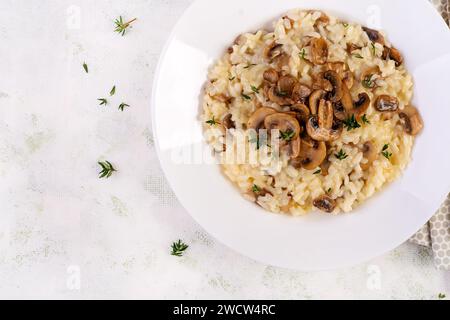 Gericht mit köstlichem Risotto mit Pilzen in Teller. Reisbrei mit Pilz und Tmyne. Warme Gerichte, italienische Küche. Draufsicht Stockfoto