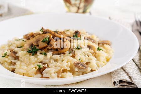 Gericht mit köstlichem Risotto mit Pilzen in Teller. Reisbrei mit Pilz und Tmyne. Warme Gerichte, italienische Küche. Stockfoto