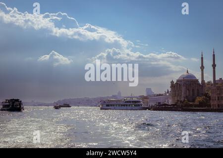 Grand Mecidiye Moschee auf dem Bosporus, gefangen von einem Boot bei Sonnenaufgang vor einer dramatischen Himmelskulisse in Istanbul, Türkei Stockfoto