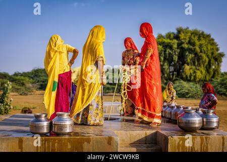 Frauen, die Wasser aus einem Brunnen der Gemeinde sammeln, Thar-Wüste, Rajasthan, Indien Stockfoto