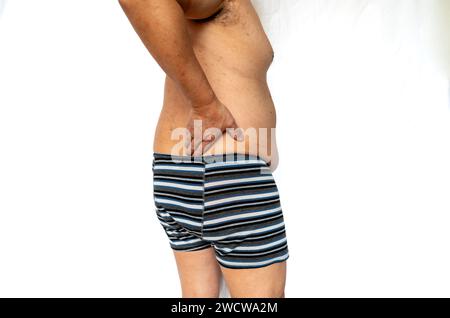 Die rechte Seitenansicht eines älteren Mannes mit Rückenschmerzen isoliert in weiß. Stockfoto