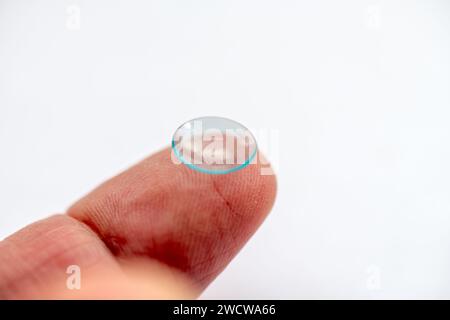 Ein Finger mit einer Augenkontaktlinse oben isoliert auf weißem Hintergrund Stockfoto