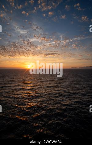 Intensiver Abendhimmel mit Flüstern, rosa Wolken und Wellen auf dem Ozean Stockfoto