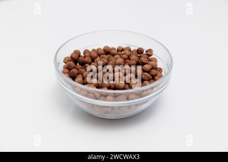 Schokoladen-knusprige Frühstückskugeln in Glasschale auf weiß Stockfoto