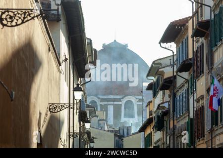 Teilweiser Blick auf Brunelleschis Kuppel in Florenz. Ungewöhnliche Aussicht bei einem Blick auf eine Gasse. Foto im Winter. Stockfoto