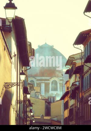 Teilweiser Blick auf Brunelleschis Kuppel in Florenz. Ungewöhnliche Aussicht bei einem Blick auf eine Gasse. Foto im Winter. Stockfoto