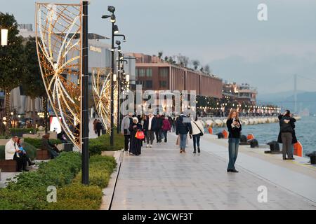 Istanbul, Türkei - 11. Dezember 2023: Die Menschen spazieren abends auf dem Stadtdamm. Galataport Promenade Stockfoto
