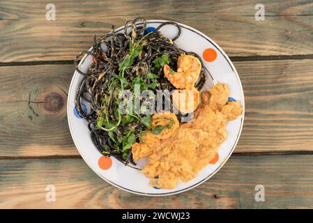 Butter Masala mit Tigergarnelen, Spaghetti nero und frischem Mikrogrün. Hausmannskost. Stockfoto