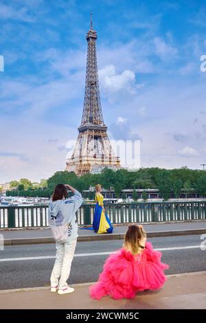 Frankreich, Paris, Bir-Hakeim-Brücke, Frau in einem Kleid in den Farben der Flagge der Ukraine und mit einem Blumenkranz, die ein Foto vor dem Eiffenturm macht Stockfoto