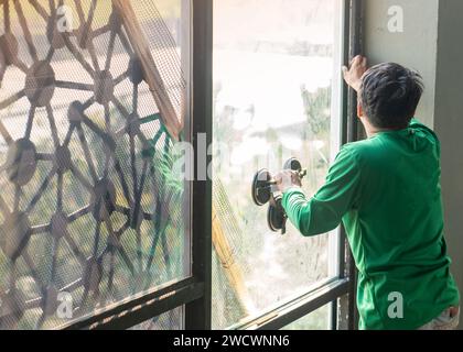 Arbeiter, der ein Fenster installiert. Platzieren einer Glasscheibe in den Rahmen. Stockfoto