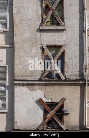 Paris, Frankreich - 09 23 2023: Blick auf eine alte Gebäudefassade mit den Fenstern, die mit Holzbrettern blockiert sind Stockfoto