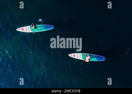 Juli 2022. Antalya, Türkei. Paare schwimmen auf Stehpaddelbrett am blauen Meer. Die Leute auf dem Red Paddle Sup Board im Mittelmeer. Luftaufnahme Stockfoto