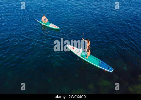 Juli 2022. Antalya, Türkei. Paare schwimmen auf Stehpaddelbrett am blauen Meer. Die Leute auf dem Red Paddle Sup Board im Mittelmeer. Luftaufnahme Stockfoto