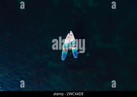 Juli 2022. Antalya, Türkei. Ein Paar, das sich auf dem Stand-Up-Paddle-Board auf dem Meer entspannt. Die Leute auf dem Red Paddle Sup Board im Mittelmeer. Luftaufnahme Stockfoto