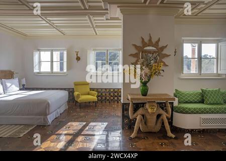 Portugal, Alentejo, Melides, Suite des Vermelho Hotels, Boutique-Hotel des Schuhdesigners Christian Louboutin, dekoriert mit eingelegten Holzparkettböden und einem schicken Rattantisch in Form eines Affen Stockfoto