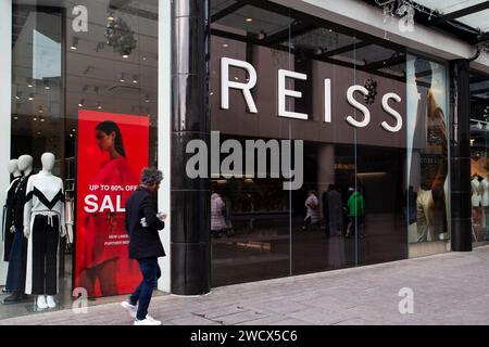 Reiss-Shop in Princesshay Exeter Devon Großbritannien, mit bis zu 60 % Rabatt auf das rote Verkaufsschild im Frontfenster mit Fußgänger, der vorbeigeht Stockfoto