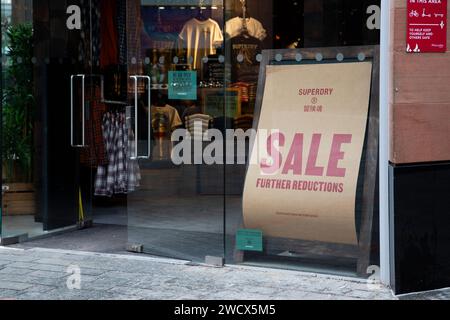 Verkaufsschild mit rotem Logo auf braunem Papier vor dem Superdry Fashion Store in Princesshay Exeter, Großbritannien Stockfoto