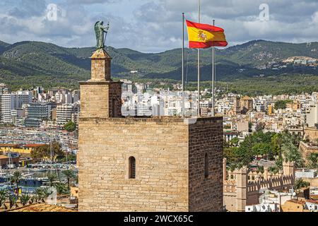 Der Turm und die spanische Flagge auf dem Königspalast von La Almudaina, von der Terrasse der mittelalterlichen Kathedrale Santa Maria von Palma. Stockfoto