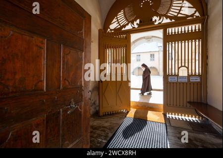 Frankreich, Haute Savoie, Aravis-Massiv, Le Reposoir, die Chartreuse du Reposoir heißt heute die Karmeliten willkommen. Der Haupteingang zum Kloster und eine Karmelitenschwester, die durch den Kreuzgang geht. Stockfoto