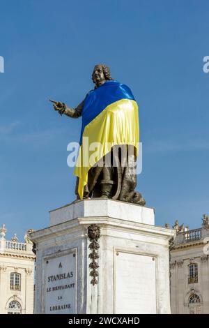 Frankreich, Meurthe et Moselle, Nancy, Stanislas-Platz (ehemaliger Königsplatz), erbaut von Stanislas Leszczynski, König von Polen und letzter Herzog von Lothringen im 18. Jahrhundert, von der UNESCO zum Weltkulturerbe erklärt, Fassaden des Stadthauses und des Grand Hotel de la reine im Hintergrund; und Statue von Stanislas, die die Flagge von Ukrania trägt Stockfoto