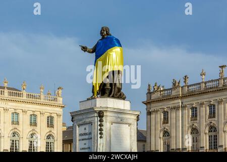 Frankreich, Meurthe et Moselle, Nancy, Stanislas-Platz (ehemaliger Königsplatz), erbaut von Stanislas Leszczynski, König von Polen und letzter Herzog von Lothringen im 18. Jahrhundert, von der UNESCO zum Weltkulturerbe erklärt, Fassaden des Stadthauses und des Grand Hotel de la reine im Hintergrund; und Statue von Stanislas, die die Flagge von Ukrania trägt Stockfoto