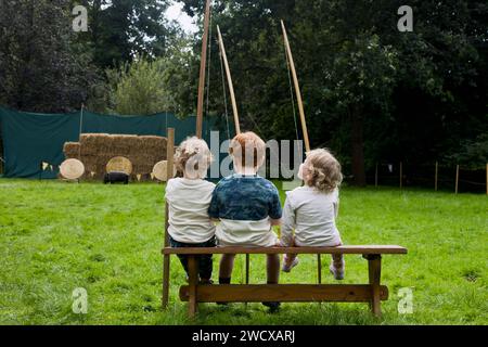 September 2023. Halesworth, Suffolk. Drei kleine Bogenschützen warten während der Halesworth 800-Festlichkeiten auf den Bogenschießunterricht. Im Stadtpark von Halesworth treffen sich Reenactoren, historische Künstler und Aussteller, um das 800-jährige Jubiläum der Marktstadt Halesworth zu feiern. König Heinrich III. Verlieh der Stadt Suffolk 1223 eine Marktcharta. Stockfoto