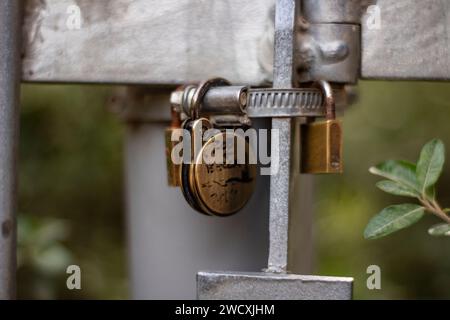 Vorhängeschloss hängt am Handlauf. Auf dem Vorhängeschloss die Namen der Liebenden, die ihn gehängt haben. Der Hintergrund ist unscharf. Stockfoto