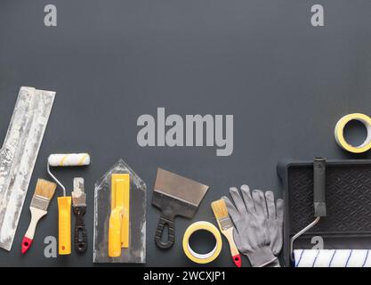 Werkzeuge und Zubehör für die Renovierung und Reparatur von Häusern auf grauem Hintergrund. Flache Anordnung mit Kopierbereich von oben. Stockfoto