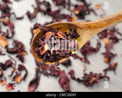 Ein Nahfoto von getrockneten Hibiskus-Teeblättern auf einem Holzlöffel. Stockfoto