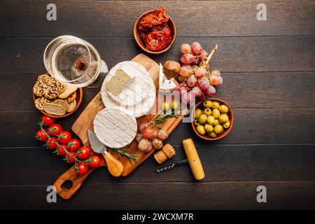 Käseplatte mit Brie, Camembert, Trauben, Oliven und Tomaten Stockfoto