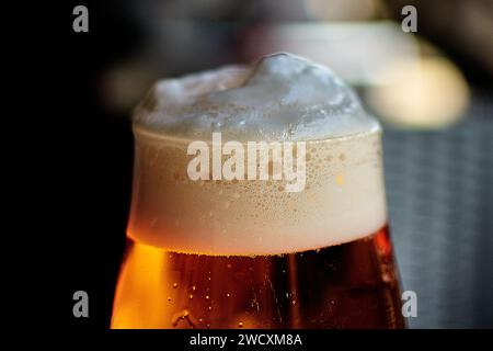 Ein Pint Bier mit cremeweißem Schaum in einem Glasglas und ein Weizenbier mit tiefgelbem Stockfoto