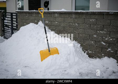 Eine gelbe Schaufel in einem Schneehaufen. Stockfoto