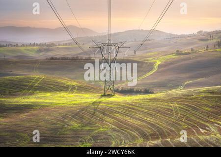 Elektrischer Übertragungsturm, der eine Freileitung in der toskanischen Landschaft unterstützt. Italien Stockfoto