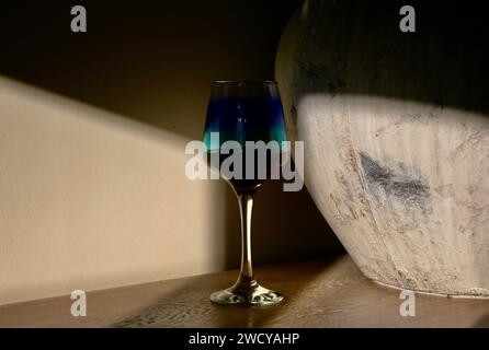 Ein Glas Rotwein, das im Schatten lauert Stockfoto