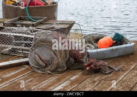 Fischernetz und Ausrüstung liegen auf einer Holzbrücke im Dock Stockfoto