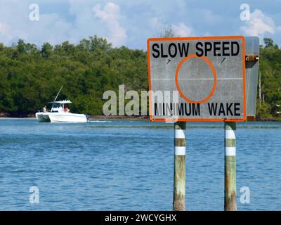 Naples, Florida, Vereinigte Staaten - 2. August 2012: Langsames Warnschild mit Boot im Hintergrund. Stockfoto