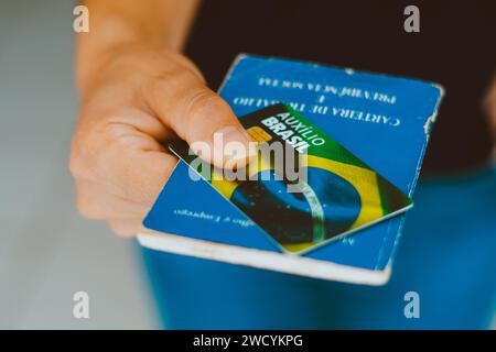 Brasilien. Januar 2024. In dieser Abbildung ist die Hand zu sehen, die die Auxílio Brasil-Karte (Bolsa Família) und Carteira de Trabalho e Previdência Social hält. (Foto von Rafael Henrique/SOPA Images/SIPA USA) *** ausschließlich für redaktionelle Nachrichten *** Credit: SIPA USA/Alamy Live News Stockfoto
