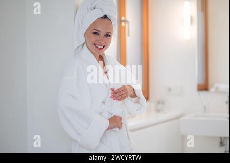 Süße, lächelnde junge Frau, die sich nach dem Duschen perfekt fühlt Stockfoto