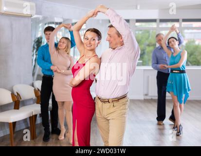 Gruppe verschiedener Altersgruppen aktive Menschen in festlicher Kleidung tanzende Tanzbewegungen im Atelier Stockfoto