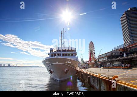 Ein Kreuzfahrtschiff, das neben der Mosaic Mall im Hafen von Kobe in Kobe, Präfektur Hyogo, Japan, vor Anker liegt. Stockfoto