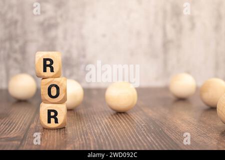 Holzwürfel mit Text ROR - Rate of Return - auf Geschäftsdokument. Stockfoto