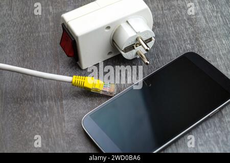 Steckdosenadapter mit Switch, Smartphone und Netzstecker, symbolisches Bild für Smart Home Stockfoto