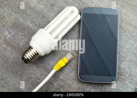 Energiesparlampe, Smartphone und Netzstecker, symbolisches Bild für Smart Home Stockfoto